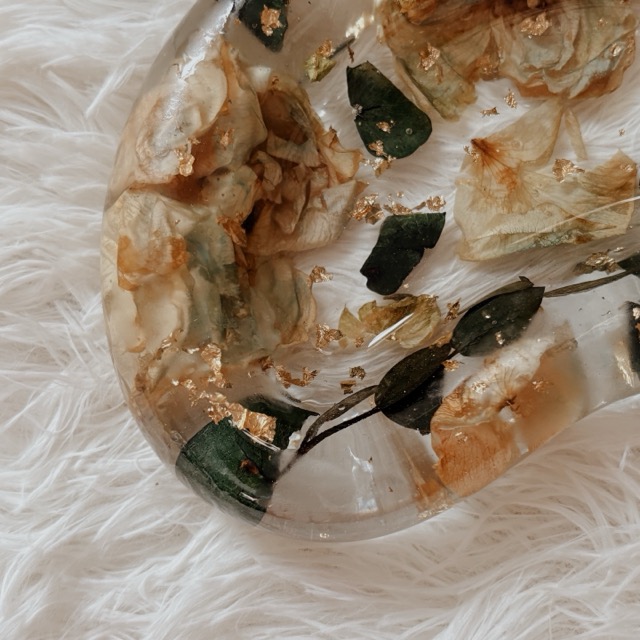 Close-up of eucalyptus leaves and cream petals inside a resin trinket tray