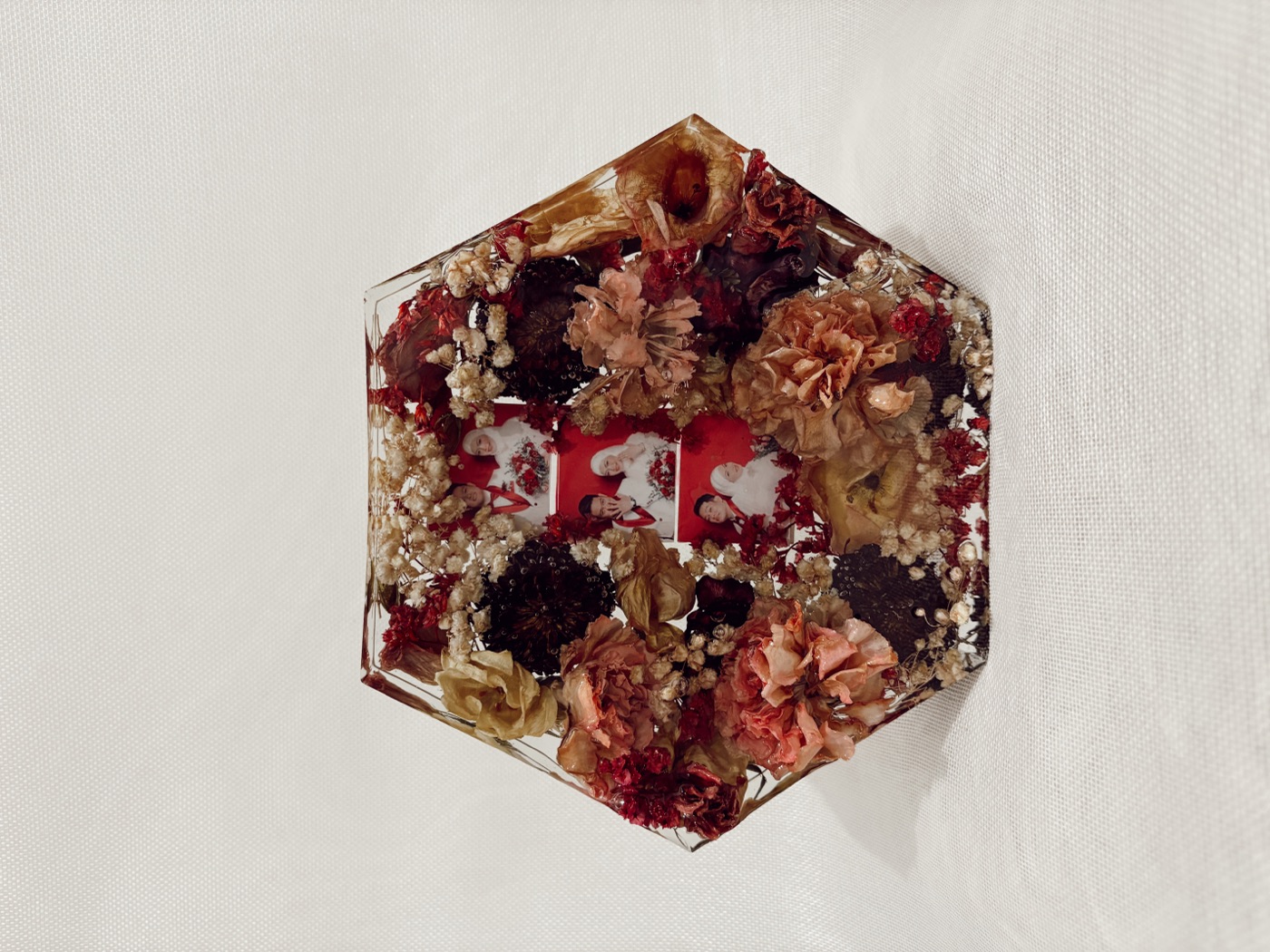 Large hexagonal resin block holding preserved wedding flowers and photos