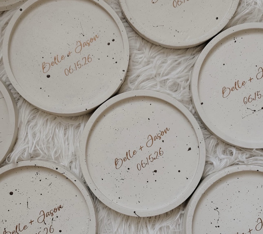Round speckled cement coasters personalized with Belle + Jason and a wedding date